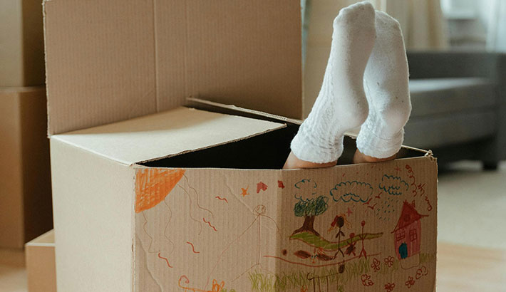 A kid's feet sticking out of a moving box