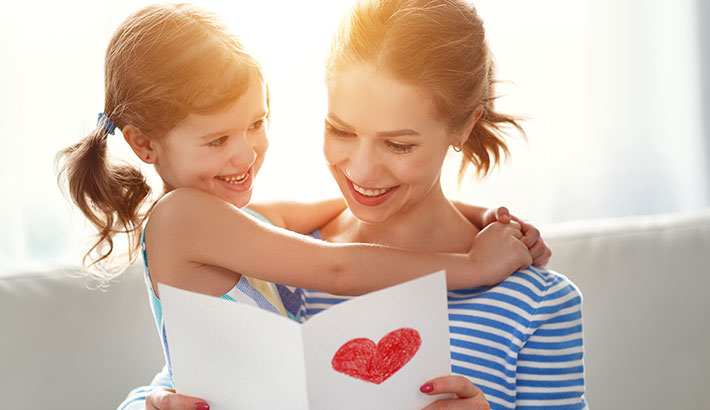 A Child and Stepparent reading a card together