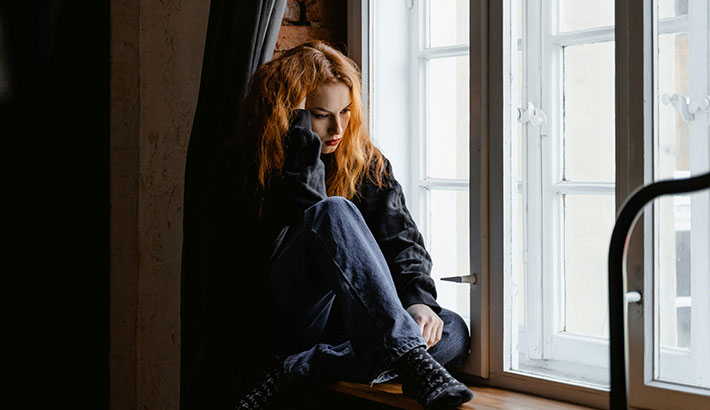 Sad Woman Sitting at Window