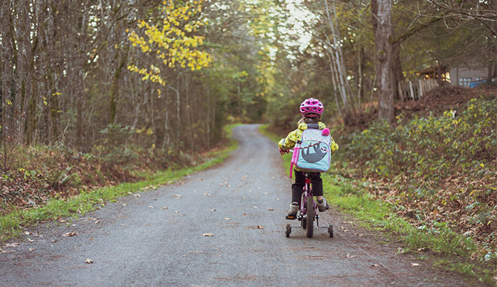 Child with helmet riding bike