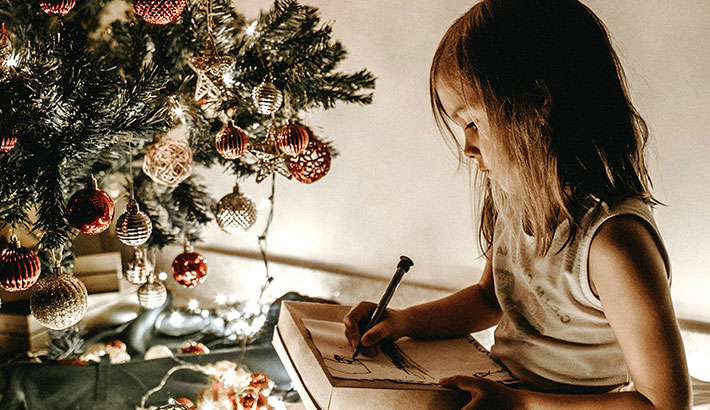 Little Girl Colouring Under Christmas Tree