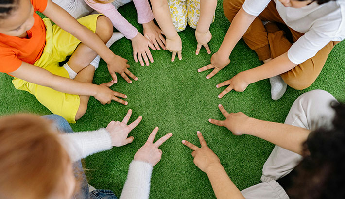 Children in a Circle Holding Out Different Numbers of Fingers